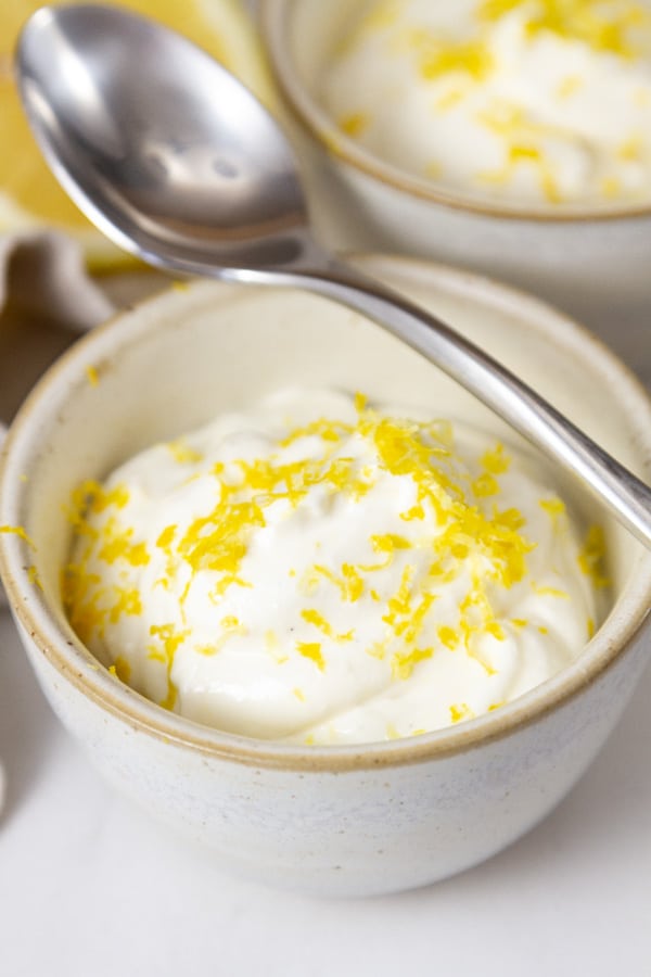 close up on a dish of pudding made with cottage cheese and lemon and a spoon on top of the dish.